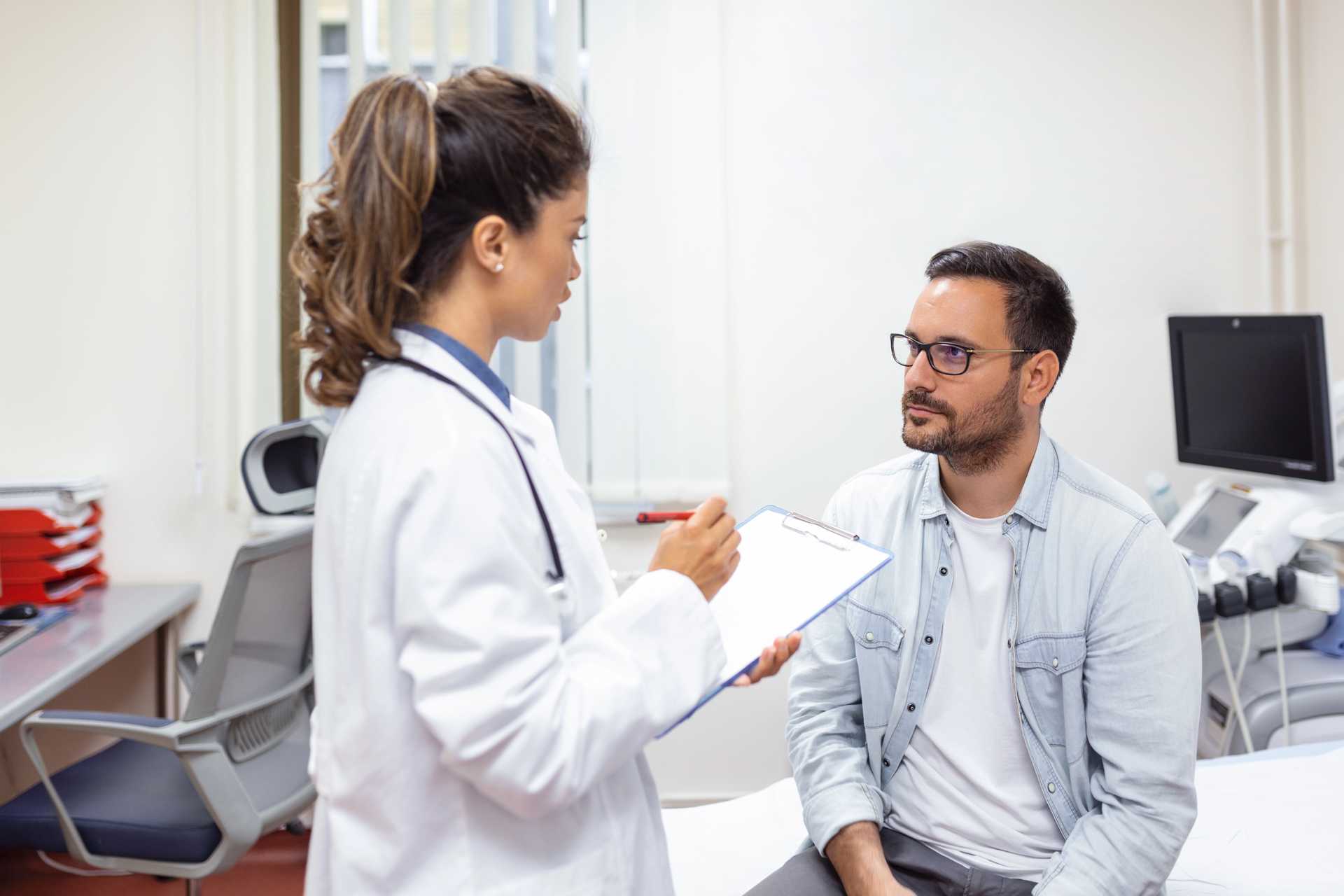 Paciente en camilla, médico explicando procedimiento de tratamiento del dolor