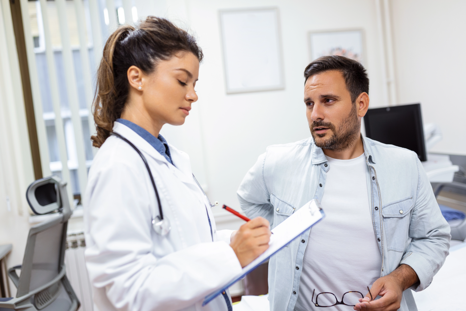 Médico neurocirujano revisando resonancia cerebral con paciente o familiar