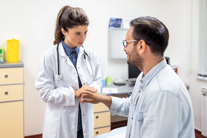 Paciente en camilla, médico explicando procedimiento de tratamiento del dolor