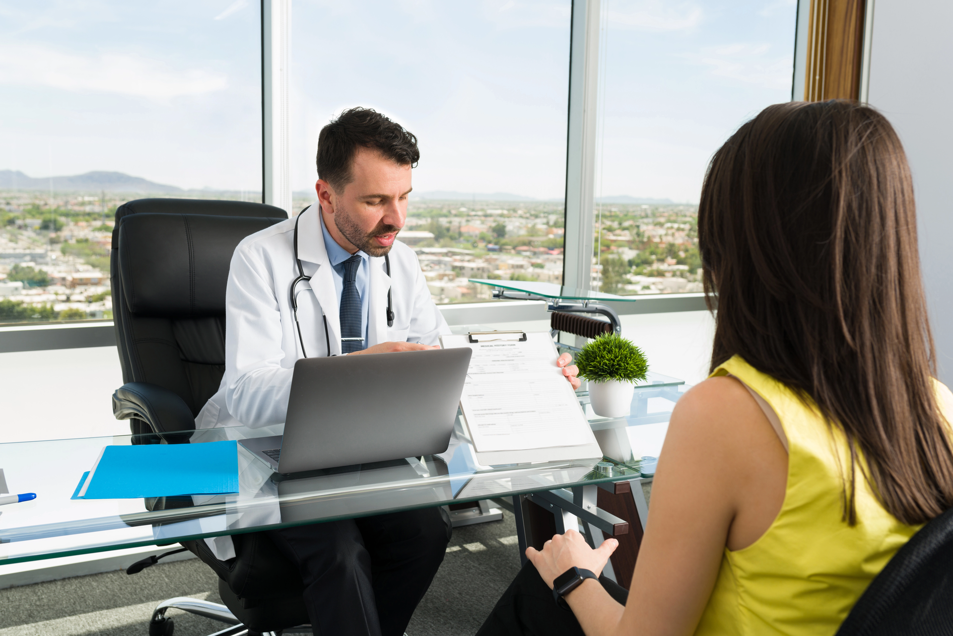 Médico explicando resonancia o tomografía en consulta especializada con paciente